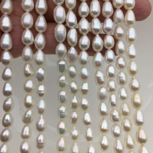 Puede incluir: Una hebra de perlas de agua dulce blancas con un brillo nacarado. Las perlas están enhebradas en un hilo transparente y tienen un tamaño aproximado de 8-9 mm.