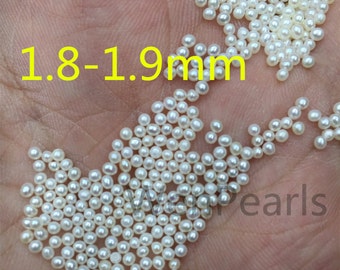 Könnte beinhalten: Nahaufnahme eines Haufens kleiner, weißer, runder Perlen. Die Perlen sind etwa 1,8-1,9 mm groß. Der Text "1,8-1,9 mm" ist im Bild sichtbar.