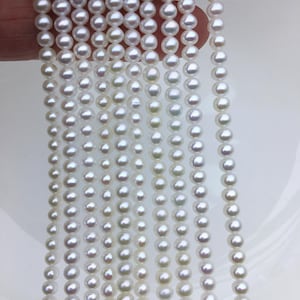 Puede incluir: Una hebra de perlas de agua dulce blancas, de aproximadamente 6-7 mm de tamaño. Las perlas están enhebradas en un hilo transparente y están listas para ser utilizadas en la elaboración de joyas.