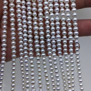 May include: Strands of white pearls, each with a lustrous sheen, are displayed. The pearls are uniform in size and shape, creating a classic and elegant look. The image showcases multiple strands, suggesting the potential for jewelry making or crafting.