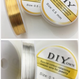 Op de afbeelding: Twee spoelen koperdraad voor het maken van sieraden. De spoelen zijn gelabeld met "DIY" en "DIYOWN". De draad is verkrijgbaar in goud en zilver. De draad is 0,5 mm en 0,3 mm dik.