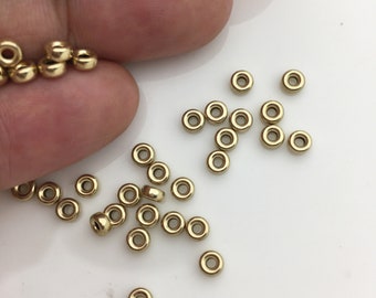 May include: A pile of small, gold-colored metal jump rings. The rings are about 5mm in diameter and are perfect for jewelry making.