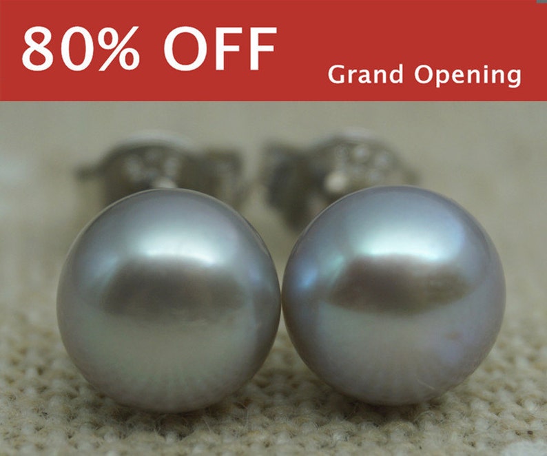 May include: A pair of silver stud earrings with a large, round, iridescent gray pearl on each earring.