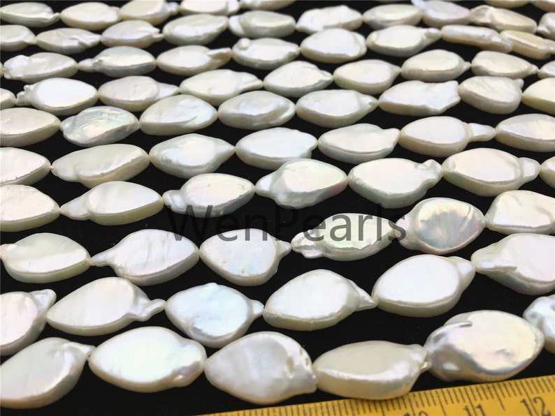 May include: A strand of white baroque freshwater pearls, each pearl is a unique, irregular shape. The pearls are arranged in a staggered pattern, creating a visually appealing design. The pearls are approximately 10-12mm in size.