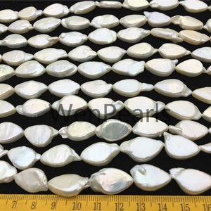 May include: A strand of white, pearlescent, oval-shaped beads. The beads are arranged in rows and are approximately 1/2 inch in length. The beads are strung on a clear thread.
