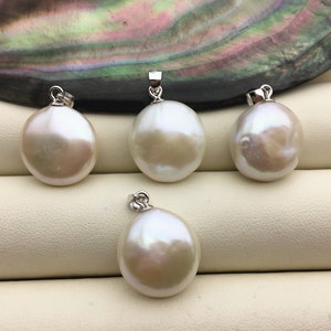 May include: Four white pearl pendants with silver clasps. The pearls are round and have a smooth, glossy finish. The pendants are arranged on a light beige surface.