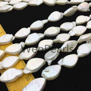 May include: A strand of white freshwater pearls with a slightly irregular, teardrop shape. The pearls are strung on a clear thread and are approximately 10mm in size.