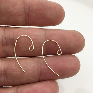 May include: Two gold-toned earring hooks, each with a curved wire and a small loop at the top.