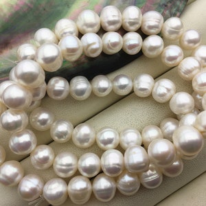 May include: Strands of lustrous, off-white pearls. The pearls are round to oval-shaped, with a smooth, iridescent surface. The pearls are strung together, creating a necklace or bracelet. The background is a neutral color.