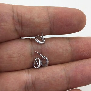 May include: Two silver-toned jewelry clasps with a small row of clear stones around the edge. The clasps are open and ready to be attached to a necklace or bracelet.