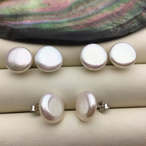 Puede incluir: Un juego de seis pendientes de perlas blancas. Las perlas son redondas y lisas, y están engastadas en plata.