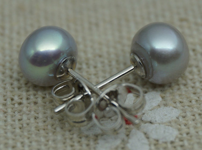 May include: A pair of silver stud earrings with a single, round, iridescent gray pearl on each earring.
