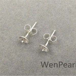 Può includere: Due perni per orecchini in argento con base rotonda. I perni sono progettati per contenere una perla o un'altra pietra preziosa.