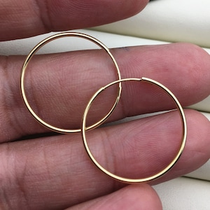 Op de afbeelding: Een paar gouden creolen. De oorbellen zijn simpel en klassiek en zouden een geweldige aanvulling zijn op elke sieradencollectie.