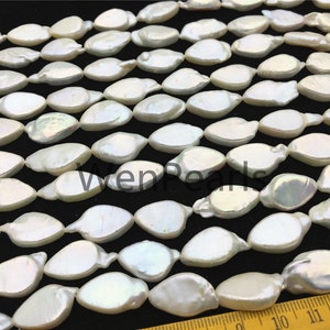 May include: A strand of white freshwater pearls with an iridescent sheen. The pearls are shaped like teardrops and are arranged in a staggered pattern. The pearls are approximately 10 mm in length.