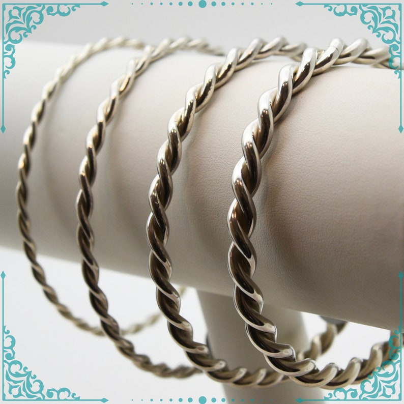 May include: Three silver bangle bracelets with a twisted rope design.