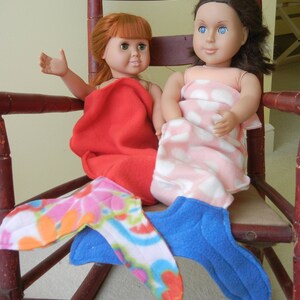 Image of dolls wearing doll mermaid tails:  red with flowered  tail  and  pink/white polka dot  with blue tail