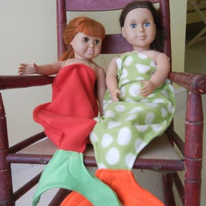 Image of dolls wearing  mermaid tails:  red  with green tail and  green/white polka dot  with orange  tail
