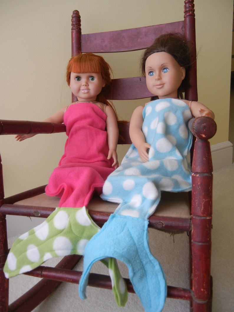 Image of dolls wearing  mermaid tails:  hot pink with green / white polka dot tail  and  blue /white polka dot  with blue tail