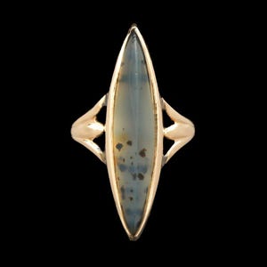 May include: A gold ring with a gray and brown agate stone set in a marquise shape.