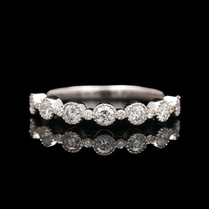 Puede incluir: Un anillo de banda de plata con una fila de diamantes redondos engastados.