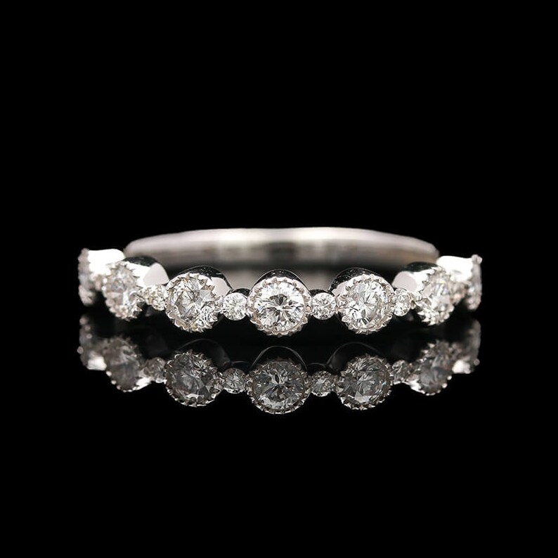 Puede incluir: Un anillo de banda de plata con una fila de diamantes redondos engastados.