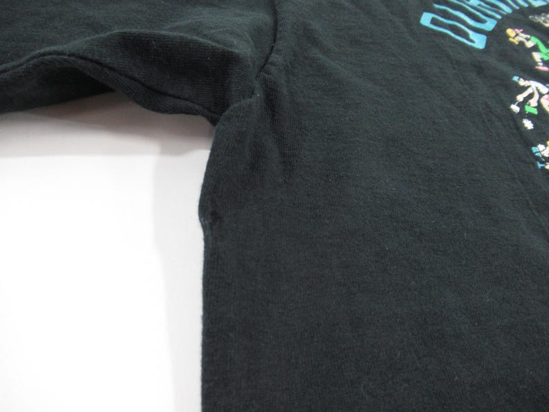 Puede incluir: Camiseta negra de manga larga con un estampado gr&aacute;fico colorido de un grupo de personas bailando. El texto "Dancing Queen" est&aacute; impreso en la camiseta.