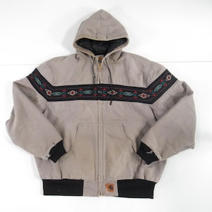 May include: A gray hooded jacket with a black zipper and a black and brown patterned band across the chest. The jacket has a Carhartt logo on the bottom left side.