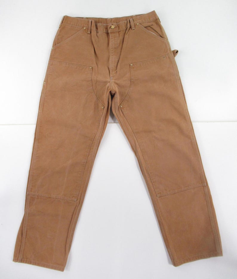 Puede incluir: Un pantal&oacute;n de trabajo marr&oacute;n con m&uacute;ltiples bolsillos y rodillas reforzadas.