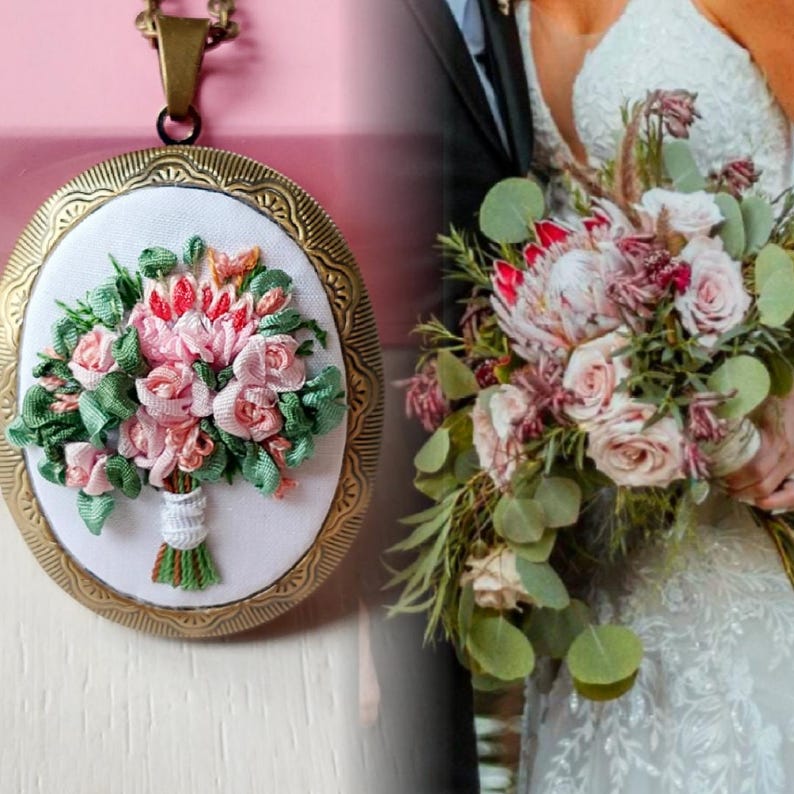 May include: A gold locket necklace with a white background and a pink and green silk flower bouquet embroidered inside. The locket is open and the bouquet is visible. The locket is on a pink background. The image also shows a bride holding a bouquet of pink and white flowers.