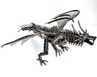 May include: A metal dragon sculpture made from screws, bolts, and other metal pieces. The dragon has wings, a long tail, and a fierce expression.