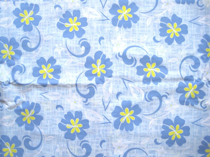 Puede incluir: Tela azul claro con un estampado floral repetitivo. El dise&ntilde;o presenta flores azules con centros amarillos, detalles blancos y l&iacute;neas azules onduladas sobre un fondo texturizado.