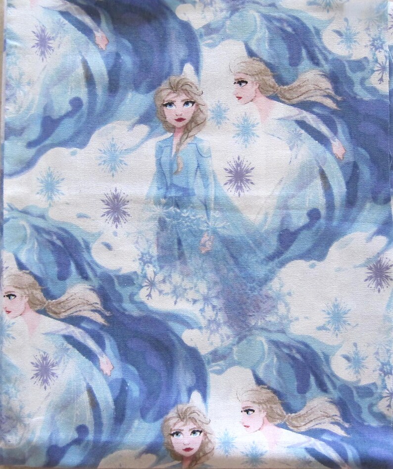 Puede incluir: Tela estampada con un dise&ntilde;o repetido de una mujer rubia con un vestido azul, rodeada de formas fluidas azules y blancas y copos de nieve. La mujer tiene una expresi&oacute;n seria y es el foco central del dise&ntilde;o. El fondo es azul claro y blanco.