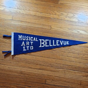 May include: A blue felt pennant with white lettering that reads "Musical Art Ltd Bellevue".