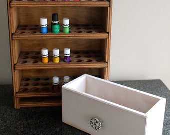 May include: Wooden shelf unit with multiple shelves for storing essential oil bottles. The shelf unit has a white drawer with a decorative knob. The shelf unit is made of wood and has a natural finish. The drawer is made of white painted wood.