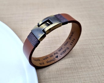 May include: Brown leather bracelet with a brass clasp. The bracelet is engraved with the text "David I wish with all my love now & forever Victoria xxxx".
