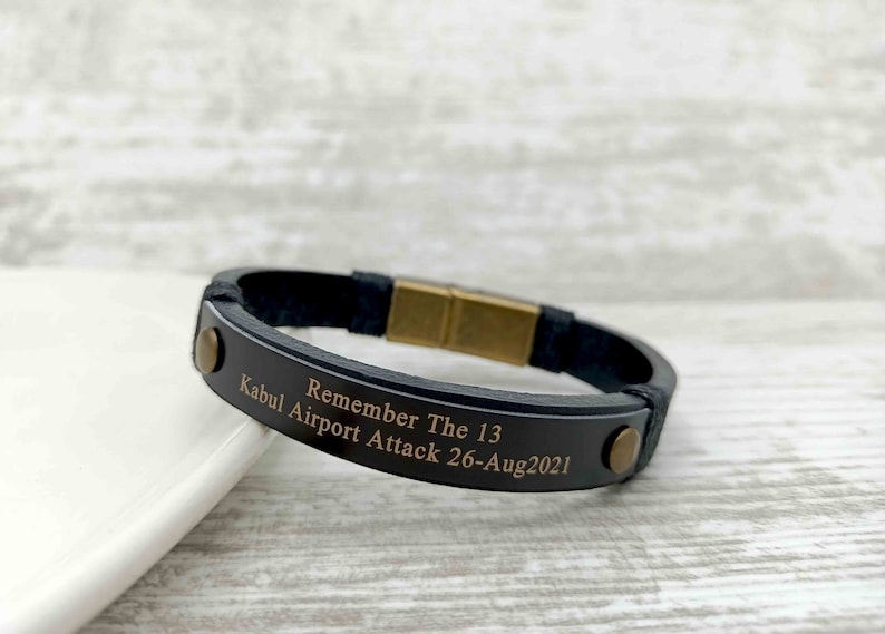 Puede incluir: Pulsera de cuero negro con cierre dorado y texto grabado: "Remember The 13 Kabul Airport Attack 26-Aug2021".