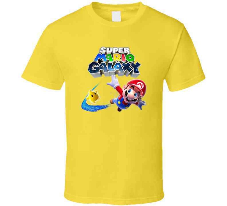 May include: Yellow t-shirt with a graphic of Mario from Super Mario Galaxy. The graphic shows Mario in a red and blue suit, flying through the air with a yellow star. The text "Super Mario Galaxy" is written in colorful letters above Mario.
