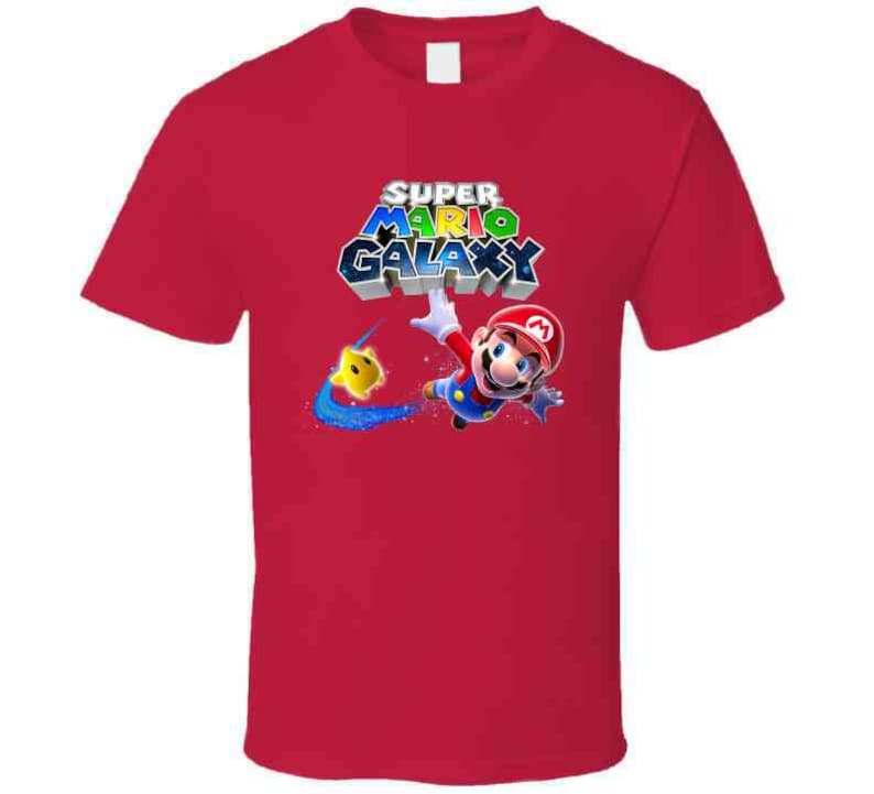 May include: Red t-shirt with a graphic of Super Mario Galaxy. The graphic features Mario in a blue and red suit, flying through space with a yellow star.