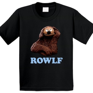 May include: Black t-shirt with a brown cartoon dog wearing a blue collar and the word "ROWLF" in blue letters.