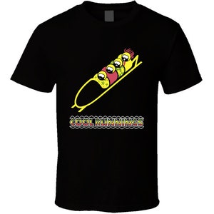May include: Black t-shirt with a yellow bobsled and four cartoon figures in red, green, and yellow helmets. The text "COOL RUNNINGS" is printed in rainbow colors below the bobsled.
