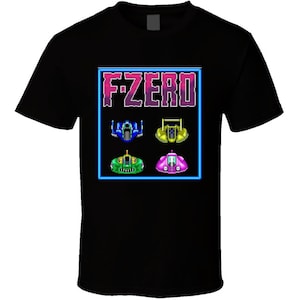 May include: Black t-shirt with a graphic of the video game "F-Zero" with the title in pink and blue text and four different spaceships in blue, green, yellow, and pink.