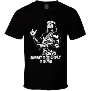 May include: Black t-shirt featuring a white silhouette of Jimmy Superfly Snuka, a professional wrestler, in a wrestling pose. The text "Jimmy Superfly Snuka" is printed in white below the image.