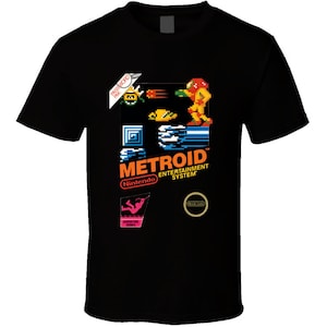 May include: Black t-shirt with a retro video game design featuring the text "METROID" and a pixelated image of a character from the game. The design also includes the text "Nintendo Entertainment System".
