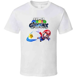 May include: White t-shirt with a colorful Super Mario Galaxy logo and a graphic of Mario flying through the air.