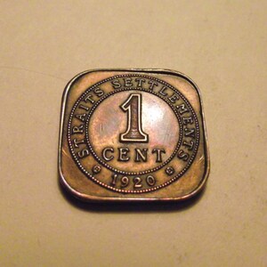 May include: A copper-coloured coin with the inscription "Straits Settlements 1 Cent 1920" around the edge.