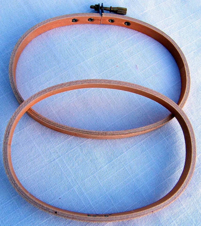 May include: Two wooden embroidery hoops, one nested inside the other. The larger hoop is 10 inches in diameter and the smaller hoop is 8 inches in diameter. Both hoops are made of natural wood and have a smooth finish.