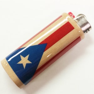 Peut inclure: Un briquet en bois avec un motif de drapeau portoricain rouge, blanc et bleu. Le briquet a un dessus argent&eacute; et un bouton rouge.