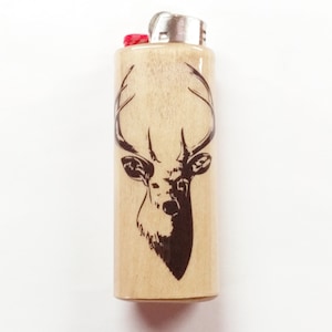 May include: A wooden lighter with a black and white silhouette of a deer head with antlers.