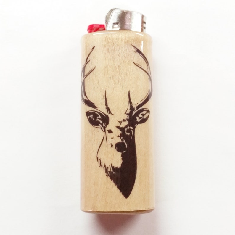 May include: A wooden lighter with a black and white silhouette of a deer head with antlers.
